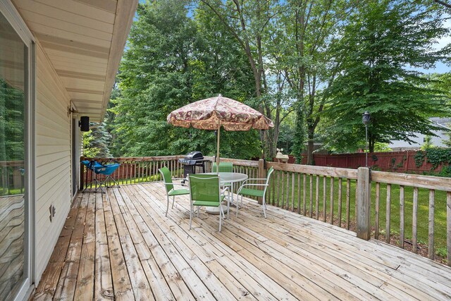 1972 Red Pine Dr, Dorr, MI 49323 - wooden deck featuring outdoor dining area, a fenced backyard, and a grill