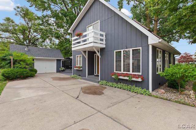 3129 Oakshade Dr, Manitou Beach, MI 49253 - view of front of house featuring a balcony, an outbuilding, driveway, and board and batten siding