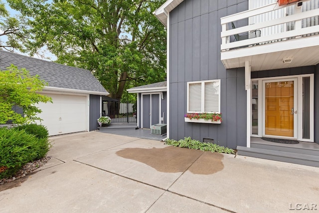 3129 Oakshade Dr, Manitou Beach, MI 49253 - view of property exterior with a garage, driveway, a balcony, board and batten siding, and a shingled roof