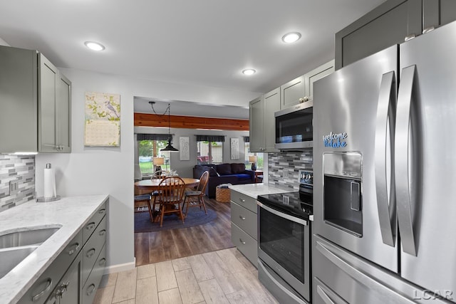 3129 Oakshade Dr, Manitou Beach, MI 49253 - kitchen featuring stainless steel appliances, tasteful backsplash, light stone counters, gray cabinetry, and recessed lighting
