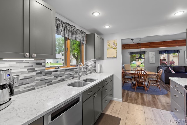 3129 Oakshade Dr, Manitou Beach, MI 49253 - kitchen featuring stainless steel dishwasher, tasteful backsplash, light wood-type flooring, light stone countertops, and open floor plan