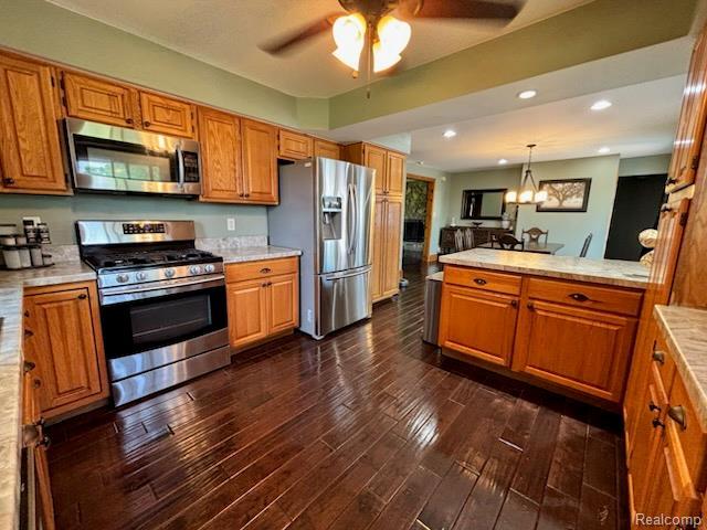 3985 Wadhams Rd, China, MI 48054 - kitchen with stainless steel appliances, light countertops, dark wood-style flooring, brown cabinets, and recessed lighting
