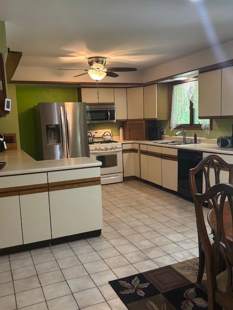 43618 Carla Dr, Paw Paw, MI 49079 - kitchen featuring stainless steel appliances, light countertops, a ceiling fan, and light tile patterned floors