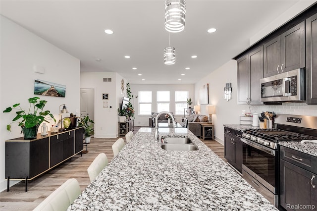 5973 Stella, Troy, MI 48085 - kitchen featuring stainless steel appliances, recessed lighting, light wood-type flooring, open floor plan, and light stone countertops