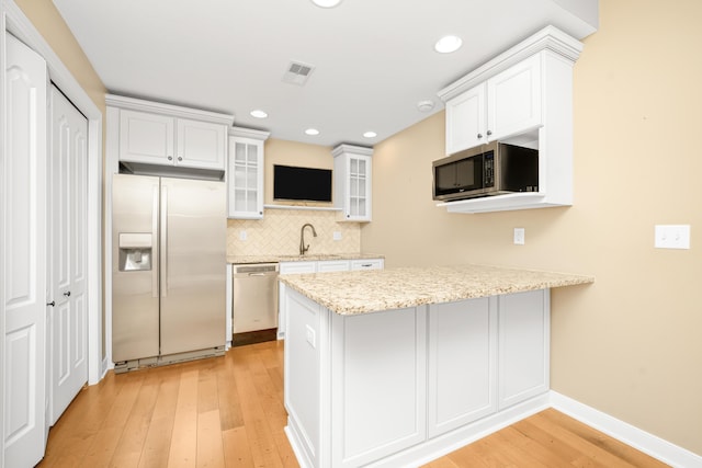 7226 Breton Woods Ct, Kalamazoo, MI 49009 - kitchen with appliances with stainless steel finishes, a peninsula, light wood-style flooring, glass insert cabinets, and white cabinets