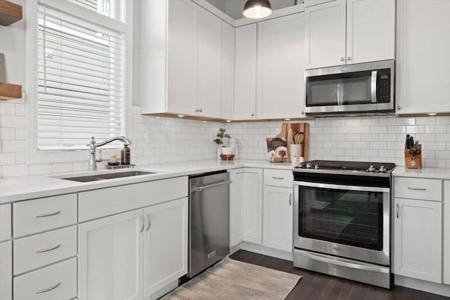 230 Cavelier Ave, Saint Joseph, MI 49085 - kitchen with stainless steel appliances, white cabinetry, light countertops, dark wood-type flooring, and tasteful backsplash