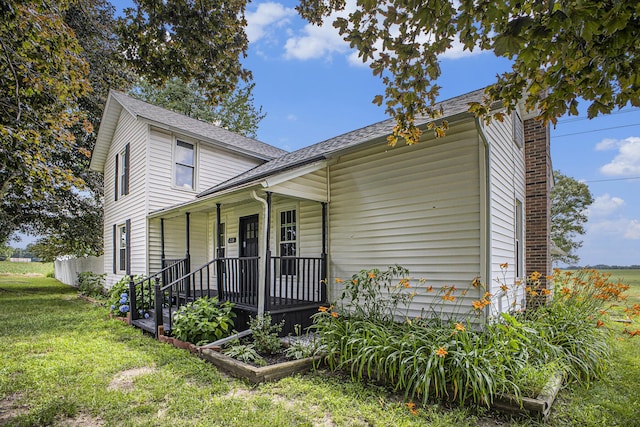 238 Maple Rd, Quincy, MI 49082 - view of front facade featuring a porch, a front yard, a chimney, and roof with shingles