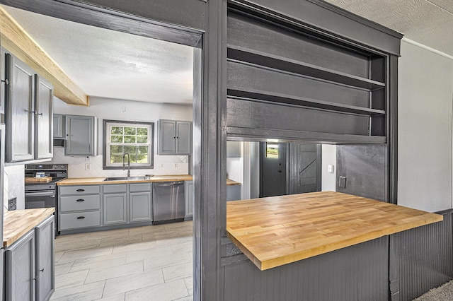 238 Maple Rd, Quincy, MI 49082 - kitchen featuring wooden counters, appliances with stainless steel finishes, gray cabinetry, tasteful backsplash, and a textured ceiling
