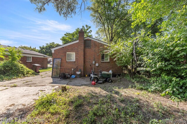 496 Lenoir Ave, River Rouge, MI 48218 - rear view of property featuring a chimney and brick siding