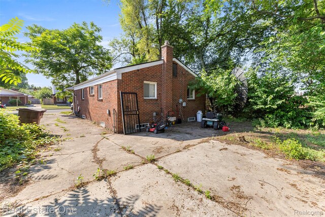 496 Lenoir Ave, River Rouge, MI 48218 - rear view of house with brick siding and a chimney