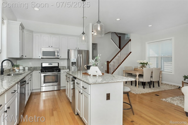 3666 Phillips Ave, Berkley, MI 48072 - kitchen with stainless steel appliances, a kitchen bar, light wood-style floors, a center island, and recessed lighting