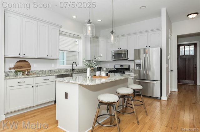 3666 Phillips Ave, Berkley, MI 48072 - kitchen with stainless steel appliances, white cabinetry, a center island, light wood-style flooring, and recessed lighting