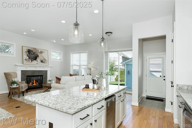 3666 Phillips Ave, Berkley, MI 48072 - kitchen with light wood-style flooring, a tile fireplace, white cabinetry, pendant lighting, and recessed lighting