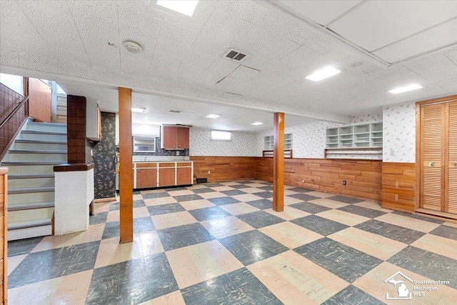 1534 London St, Lincoln Park, MI 48146 - finished below grade area featuring tile patterned floors, a wainscoted wall, stairs, wood walls, and a drop ceiling