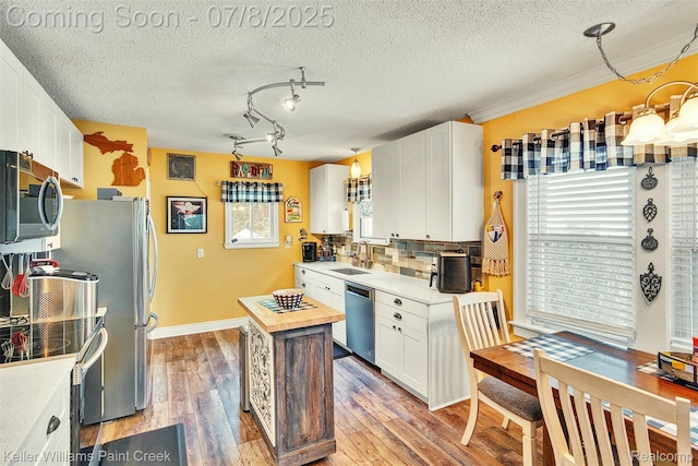 1726 Oxford Rd, Berkley, MI 48072 - kitchen featuring appliances with stainless steel finishes, white cabinetry, light wood-type flooring, backsplash, and a textured ceiling