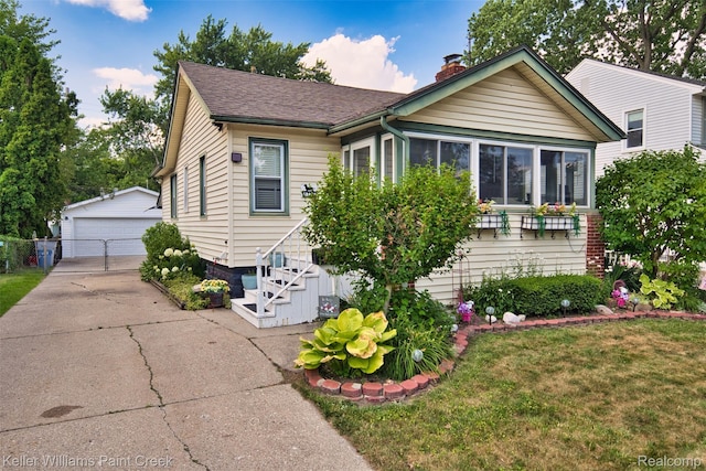 1726 Oxford Rd, Berkley, MI 48072 - bungalow with a chimney, a garage, an outdoor structure, a front yard, and roof with shingles