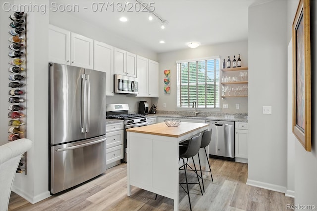3317 Parkways Blvd, Auburn Hills, MI 48326 - kitchen featuring appliances with stainless steel finishes, a kitchen bar, white cabinets, butcher block countertops, and a kitchen island