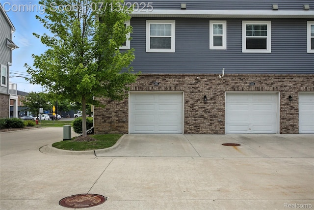 3317 Parkways Blvd, Auburn Hills, MI 48326 - view of side of home featuring an attached garage, driveway, and brick siding