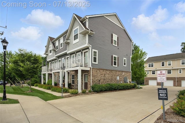 3317 Parkways Blvd, Auburn Hills, MI 48326 - view of side of home with brick siding, a balcony, a garage, and concrete driveway