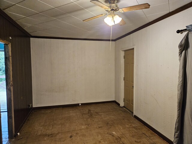 2768 W Winston Rd, Rothbury, MI 49452 - empty room featuring wood walls, ornamental molding, tile patterned floors, and ceiling fan