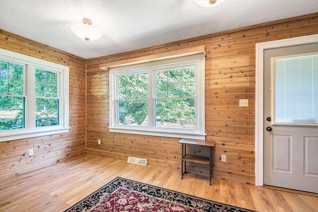 4471 Highland Ave, Benton Harbor, MI 49022 - unfurnished room featuring wood walls, light wood-type flooring, and a textured ceiling