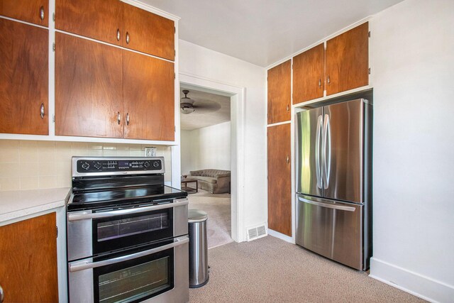 4471 Highland Ave, Benton Harbor, MI 49022 - kitchen with appliances with stainless steel finishes, light colored carpet, tasteful backsplash, light countertops, and brown cabinetry