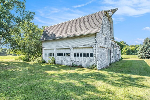 4471 Highland Ave, Benton Harbor, MI 49022 - view of property exterior featuring a detached garage, an outdoor structure, a shingled roof, and a lawn