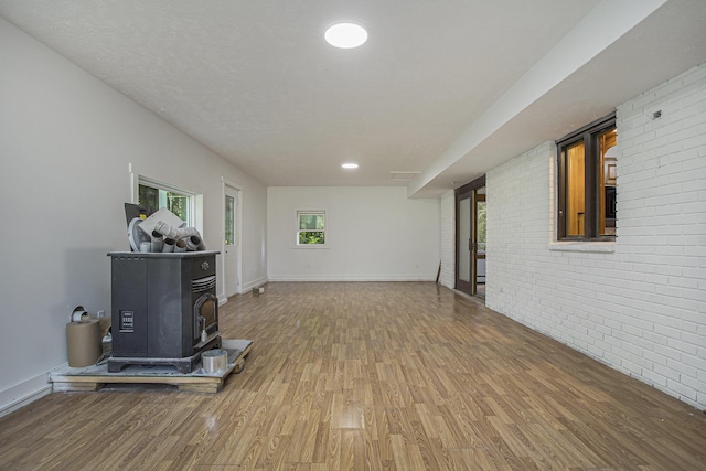 14083 M37, Battle Creek, MI 49017 - unfurnished living room with wood finished floors, a wood stove, and brick wall