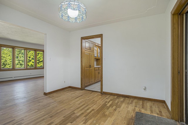 14083 M37, Battle Creek, MI 49017 - spare room featuring light wood-style floors, a baseboard radiator, and a chandelier