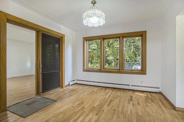 14083 M37, Battle Creek, MI 49017 - empty room with baseboard heating, light wood-type flooring, and a chandelier