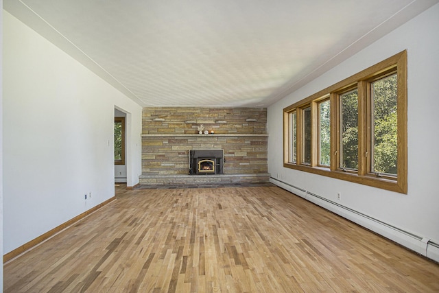 14083 M37, Battle Creek, MI 49017 - unfurnished living room featuring a baseboard heating unit, healthy amount of natural light, and light wood finished floors