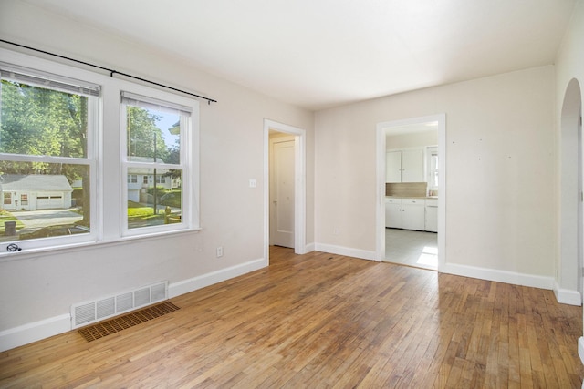 924 Royce Ave, Kalamazoo, MI 49001 - empty room with wood-type flooring and arched walkways