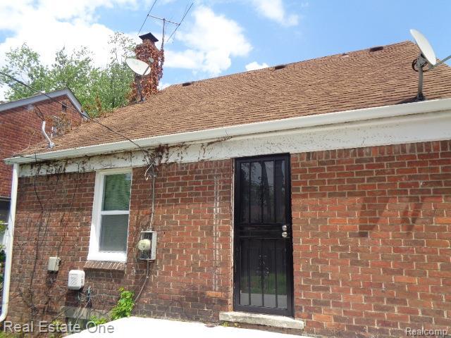 18259 Pinehurst St, Detroit, MI 48221 - doorway to property with brick siding and roof with shingles