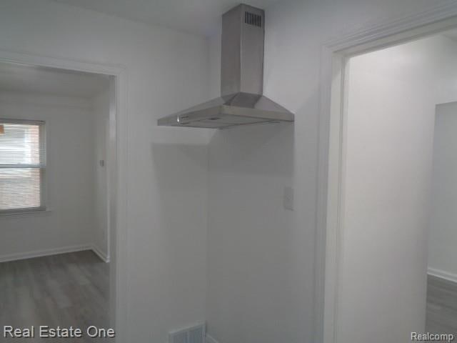 18259 Pinehurst St, Detroit, MI 48221 - detailed view of wall chimney range hood and wood finished floors