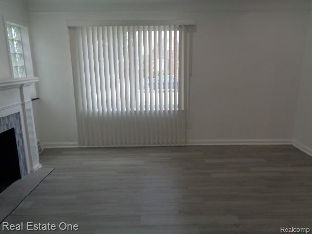 18259 Pinehurst St, Detroit, MI 48221 - unfurnished living room with wood finished floors and a premium fireplace