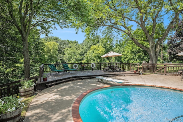 6400 N Rochester Rd, Rochester Hills, MI 48306 - view of pool featuring a wooden deck, a diving board, view of scattered trees, and a patio area