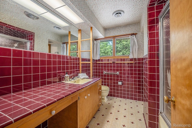 6400 N Rochester Rd, Rochester Hills, MI 48306 - full bath featuring a shower with shower door, wallpapered walls, vanity, tile walls, and tile patterned floors
