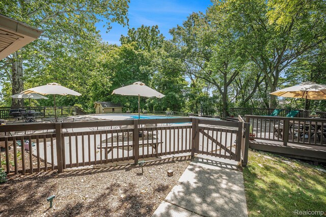 6400 N Rochester Rd, Rochester Hills, MI 48306 - view of pool featuring a wooden deck, view of scattered trees, and a storage shed
