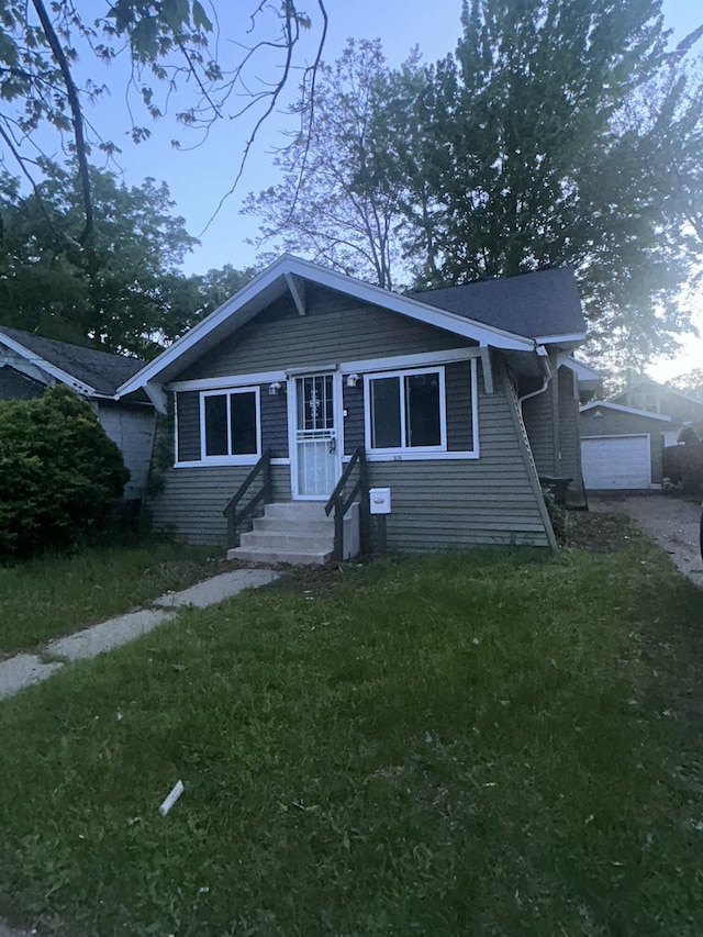 1615 Dyson St, Muskegon, MI 49442 - bungalow with entry steps, a front yard, and a garage