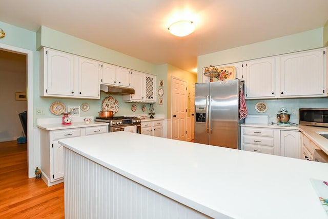 50983 Kiawah Trl, Mattawan, MI 49071 - kitchen with stainless steel appliances, under cabinet range hood, light wood-style floors, and white cabinetry