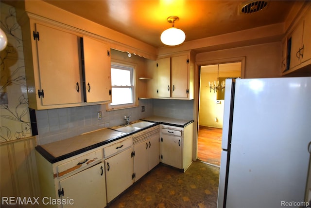 22150 Beverly St, Oak Park, MI 48237 - kitchen featuring freestanding refrigerator, tasteful backsplash, white cabinets, dark floors, and tile countertops