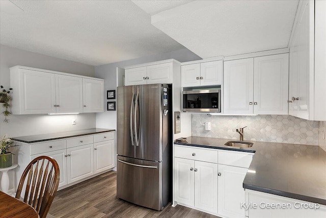 46 Counts Cove Ct, Holland, MI 49424 - kitchen with appliances with stainless steel finishes, dark wood-style floors, white cabinets, and a textured ceiling