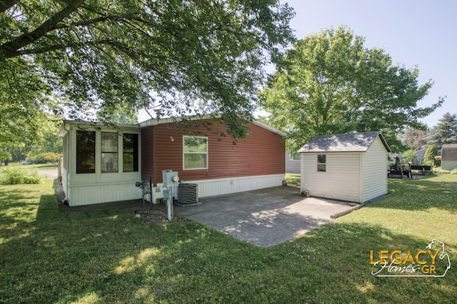 1163 Maple Leaf Ln NW, Walker, MI 49534 - back of house with a yard, a patio area, and a storage shed