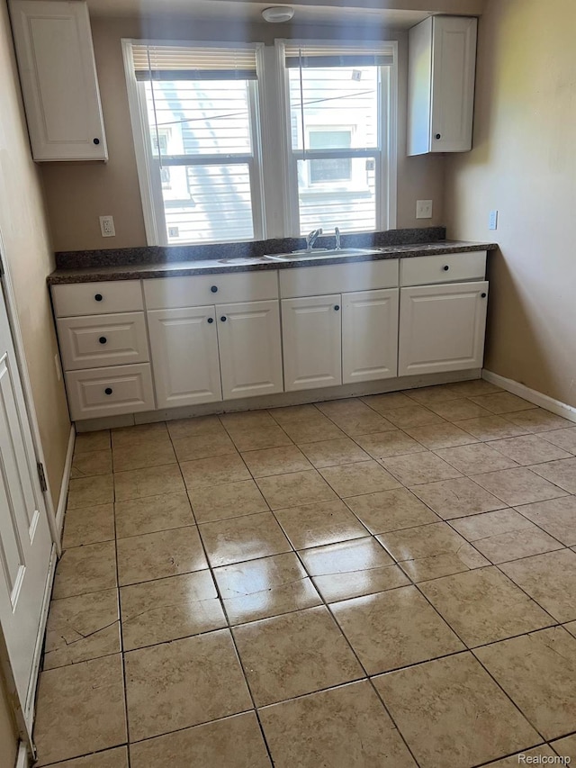 18995 Wormer St, Detroit, MI 48219 - kitchen featuring white cabinetry, light tile patterned flooring, and dark countertops