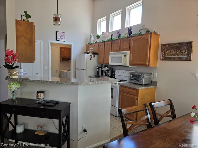 37329 Amhurst Dr Unit 23, Westland, MI 48185 - kitchen featuring white appliances, brown cabinetry, a peninsula, and light tile patterned floors