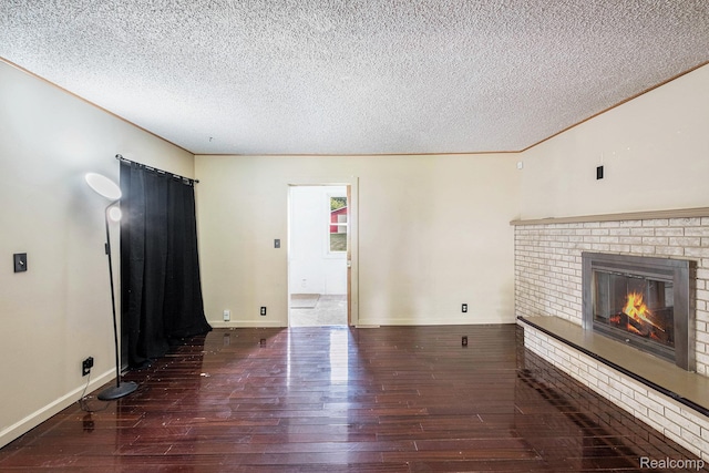 3596 Hunt Rd, Lapeer, MI 48446 - unfurnished living room featuring hardwood / wood-style flooring, a brick fireplace, and a textured ceiling