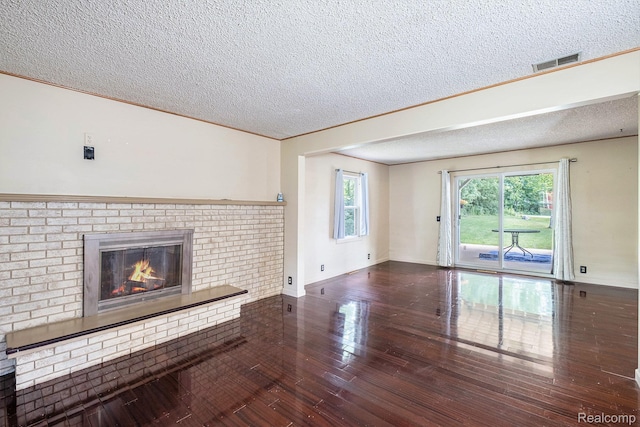3596 Hunt Rd, Lapeer, MI 48446 - unfurnished living room featuring a textured ceiling, hardwood / wood-style floors, and a fireplace