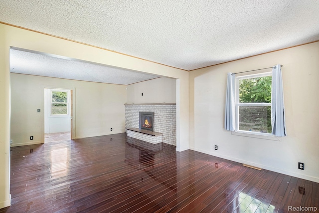3596 Hunt Rd, Lapeer, MI 48446 - unfurnished living room featuring a textured ceiling, a fireplace, hardwood / wood-style floors, and healthy amount of natural light