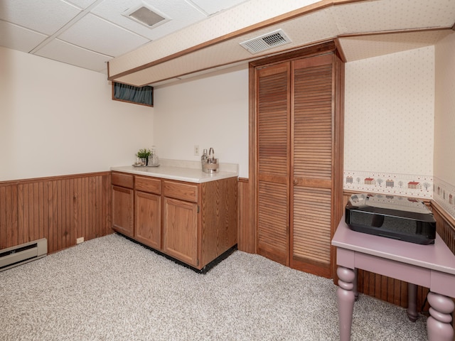 1627 Whitby Ave, Portage, MI 49024 - kitchen featuring a wainscoted wall, brown cabinetry, light carpet, a baseboard radiator, and light countertops