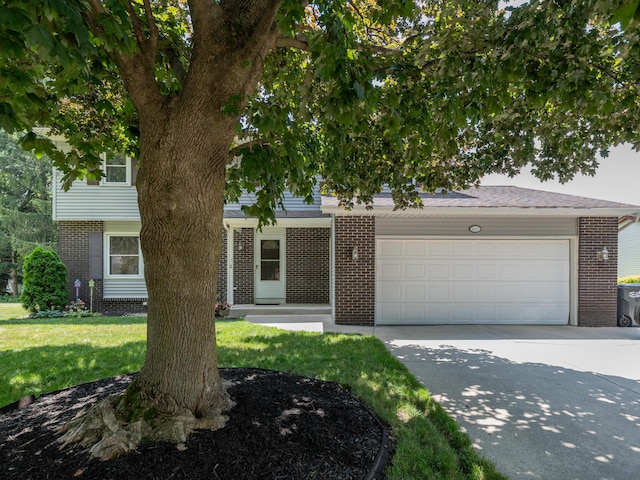 1627 Whitby Ave, Portage, MI 49024 - view of property hidden behind natural elements with brick siding, driveway, a garage, and a front lawn